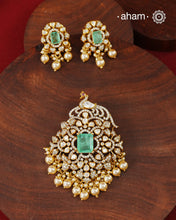 Crafted in 92.5 sterling silver with an elegant gold polish finish, this pendant and earring set features sparkling moissanite stones surrounding a lustrous green centre stone. Timeless yet striking, it is designed to add effortless sophistication to special occasions.