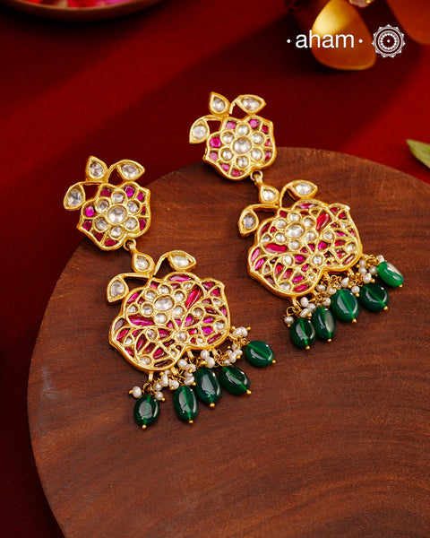 These intricately designed silver earrings are adorned with radiant Kundan, vibrant Kemp, and gleaming Emeralds, all beautifully complemented by lustrous Pearls. Finished with a luxurious Gold Polish, these earrings exude timeless elegance and are a must-have addition to any jewellery collection. Perfect for weddings, festive occasions, or adding a touch of heritage charm to your everyday look.