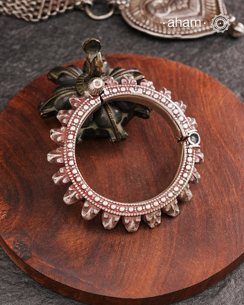 Vintage Handcrafted silver kada.The bangle has red tint to it probably due to kumkum smeared on it by the original wearer. To keep the authenticity of the bangle we have not replosihed it.