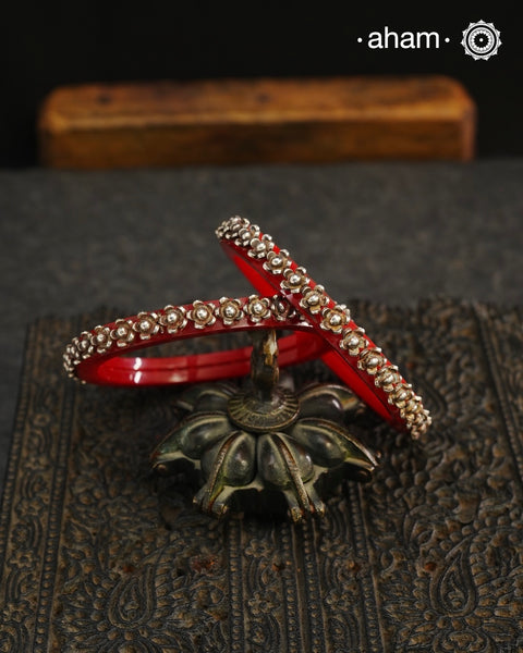 Beautiful tribal silver Bangles. Perfectly crafted silver flowers set on red plastic bangles. Comes as a set of 2 Bangles.