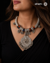 A composition of collected silver

A neckpiece that brings together fragments of the past, reimagined into a singular, striking form.

Crafted in&nbsp;silver, this piece features repurposed hasli elements, threaded together with traditional powai work. The centre is adorned with multicoloured semi-precious beads, lending a quiet vibrancy to the otherwise muted silver tones.

Delicate details emerge on closer look. Vintage toe ring accents and tribal silver finger rings repurposed as dangling elements, creat
