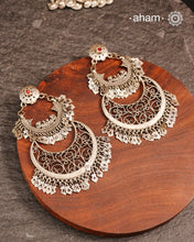 This exquisite two-layer silver chandbali earring blends traditional charm with contemporary design, creating a striking statement piece. Crafted with intricate detailing, it harmonizes classic elements and modern aesthetics, making it perfect for elevating any ensemble with elegance. Ideal for those who appreciate timeless artistry