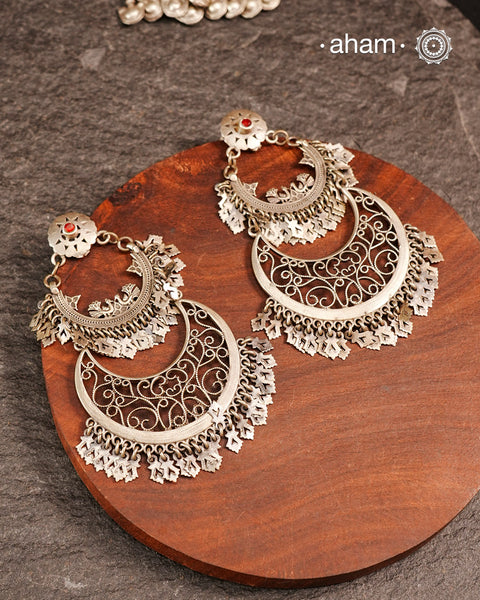 This exquisite two-layer silver chandbali earring blends traditional charm with contemporary design, creating a striking statement piece. Crafted with intricate detailing, it harmonizes classic elements and modern aesthetics, making it perfect for elevating any ensemble with elegance. Ideal for those who appreciate timeless artistry