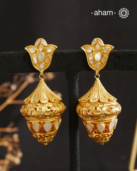 Step into the timeless elegance of our Mother of Pearl Gold Polish Silver Jhumkie. This Victorian-inspired chandelier design features lustrous gold polish and a stunning mother of pearl accent. Exquisitely crafted in silver, this is a must-have for any jewelry collection. Elevate your look with this exquisite piece.