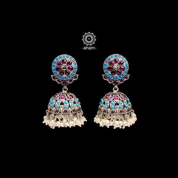 Handcrafted pair of kemp and blue coloured stone jhumkie earrings in 92.5 sterling silver. Elegant Nrityam jhumkies with intricate floral motifs and hanging cultured pearls. 