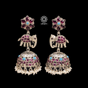 Handcrafted statement Nrityam jhumkie earrings in 92.5 sterling silver. With elegant elephant and floral motifs. Enhanced with kemp and turquoise coloured stone setting, hanging cultured pearls. 
