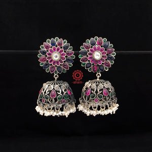 Handcrafted pair of Nrityam jhumkie earrings in 92.5 sterling silver. Comes with floral motifs, blue , green and maroon kemp stone setting and dangling cultured pearls. 