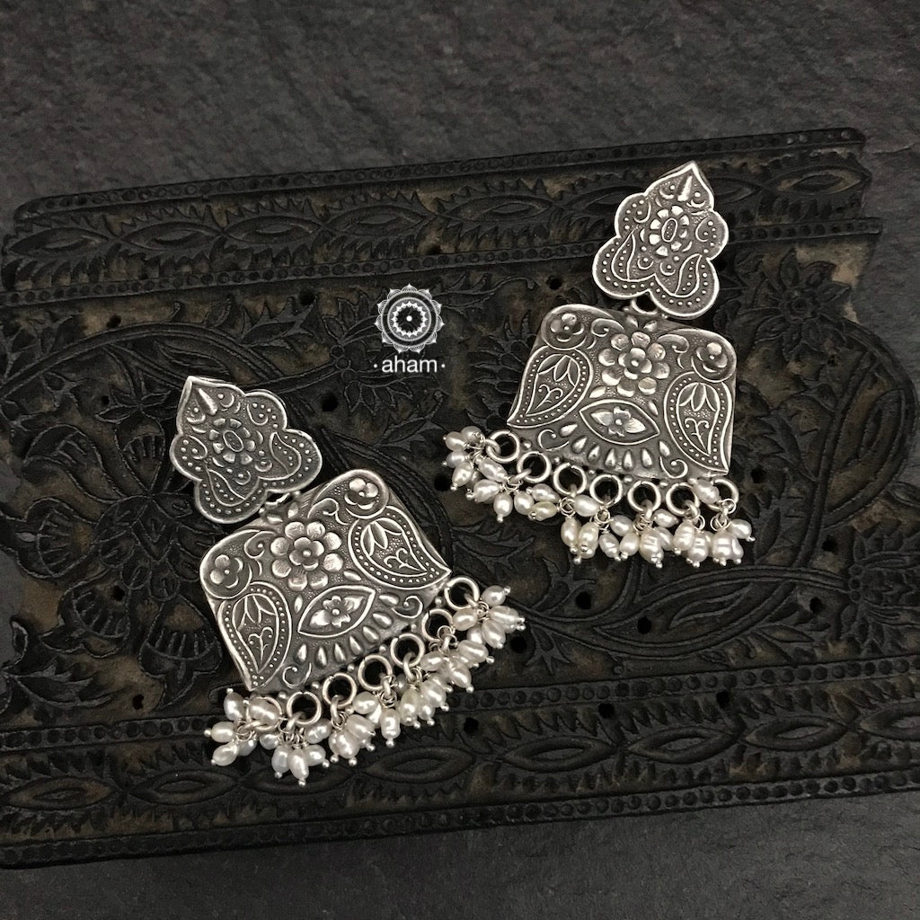 Mewad earrings with intricate floral work and cultured pearls. Handcrafted in 92.5 sterling silver. An ode to the glorious state of Rajasthan. 