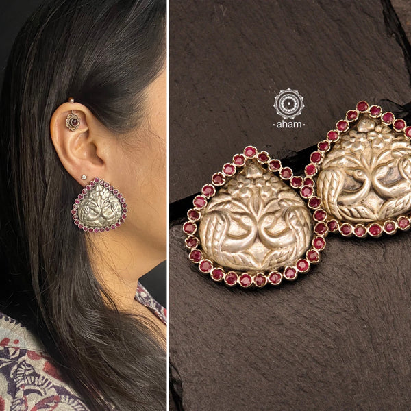 Summer love drop stud earrings with intricate double peacock motif. Handcrafted in silver with maroon coloured stone setting. Looks great with your everyday ethnic outfits.