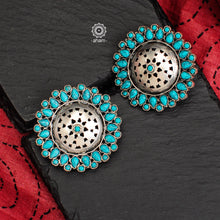 Beautiful silver studs with cut work center and turquoise coloured stone highlights. Crafted in 92.5 silver, these are great statement makers. 