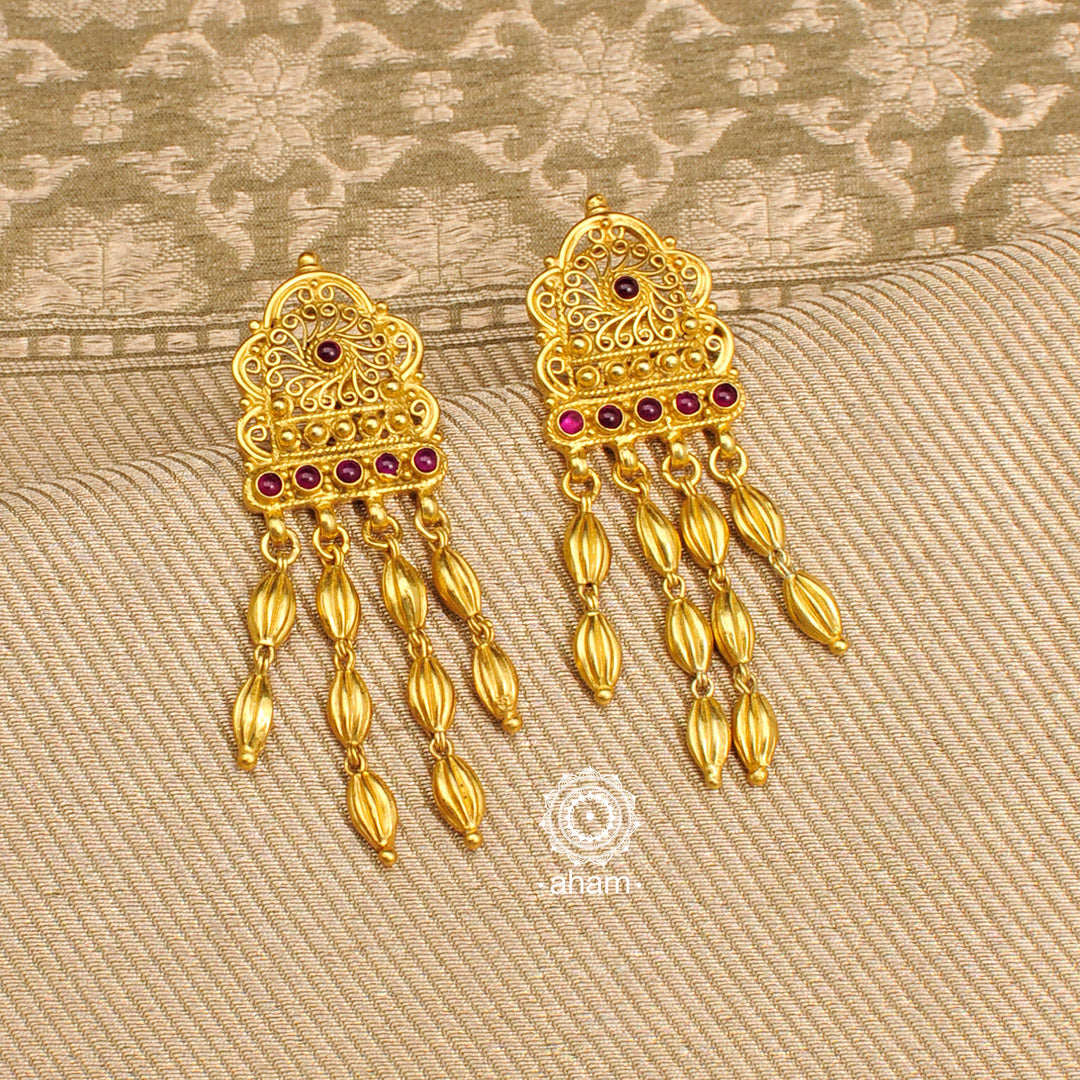Catch everyone's attention with this beautiful gold polish earrings. Handcrafted using traditional technique in silver with deep red stones. Perfect for special occasions and festivities.