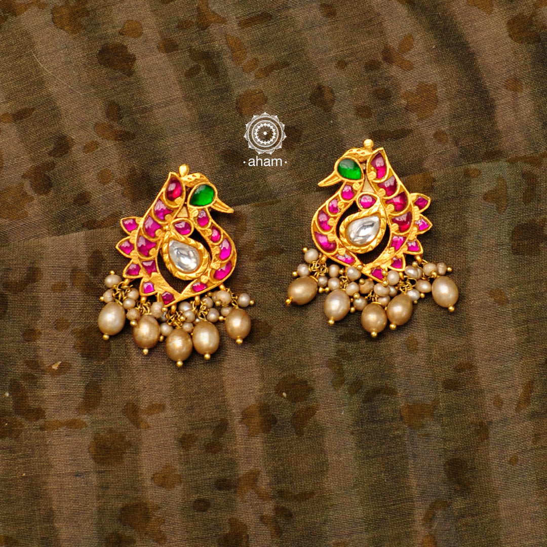 Beautiful festive peacock gold polish earrings with rani pink highlights. Handcrafted in 92.5 sterling silver with cultured pearls. Pair these elegant earrings with your favourite ethnic or fusion outfit this festive season.