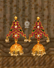 Festive gold polish jhumkie earrings with rani pink kundan work. Handcrafted using traditional methods in silver including double peacock motif and dangling cultured pearls. Style these up with your favourite ethnic outfits to dazzle up your festive looks.