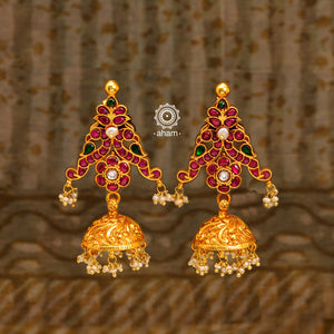 Festive gold polish jhumkie earrings with rani pink kundan work. Handcrafted using traditional methods in silver including double peacock motif and dangling cultured pearls. Style these up with your favourite ethnic outfits to dazzle up your festive looks.