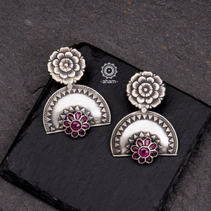 Shivneri flower earrings with rava work. Handcrafted in 92.5 sterling silver with maroon stones. Looks great with both ethnic and western outfits.