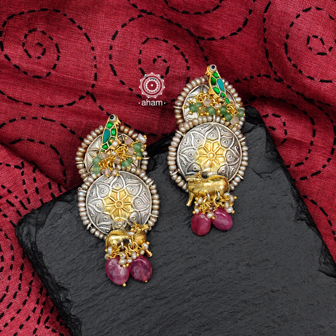 Handcrafted Noori two tone earrings in 92.5 sterling silver. Beautiful earrings with parrot motif, Kamadhenu motif, semi precious beads and embellished cultured pearls. Style this up with your favourite ethnic or fusion outfits.