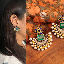Noori two tone crescent earrings with semi precious green stone. Handcrafted in 92.5 sterling silver with blue spinel flower motif. Subtle elegance that add charm to your look. 