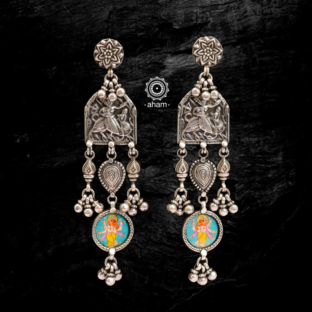 Light weight silver earrings with intricate miniature hand painted lord Ganesha motif in vibrant colours, enclosed with a glass top. Handcrafted in 92.5 silver. 