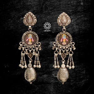 Light weight earrings with intricate miniature hand painted lord Krishna motif in vibrant colours, enclosed with a glass top. These earrings are hand crafted in 92.5 sterling silver and are pieces of wearable art. 