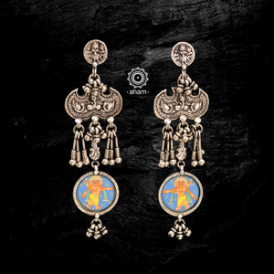 Light weight silver earrings with intricate miniature hand painted lord Ganesha motif in vibrant colours, enclosed with a glass top. Handcrafted  in 92.5 sterling silver, these are wearable art pieces. 