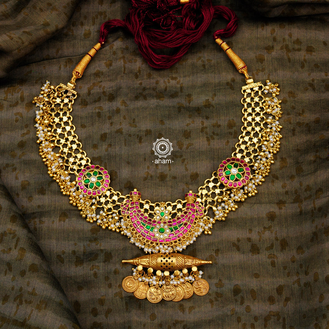 Make a sophisticated style statement with this handcrafted tribal anklet converted into an elegant amulet neckpiece. Crafted using traditional techniques in silver with gold polish, dangling cultured pearls, kundan work crescent & floral motifs. Perfect for intimate weddings and upcoming festive celebrations.
