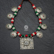 Handcrafted tribal silver neckpiece with intricate floral and peacock motifs. Beautiful tribal silver pieces threaded together including red and green work. This necklace truly exemplifies the continuity of the traditional prototypes.