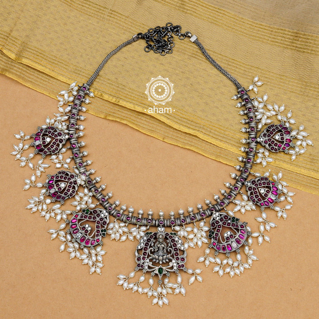 Beautiful handcrafted Guttapusalu style goddess Lakshmi neckpiece. Created in 92.5 sterling silver with intricate peacock motifs, green and maroon Kemp stone setting.    Gutta in Telugu means “Shoals of small fish”, and Pusalu means “beads”. Set in a melange of kundan, green and kemp stones fringed with bunches of small pearls, the Guttapusalu are a most have in every jewellery lovers collection. These are timeless pieces for generations to come.