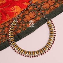 Flaunt beautiful Noori two tone short neckpiece. Handcrafted in 92.5 sterling silver with maroon semi precious stones. An elegant piece perfect for special occasions and family gatherings.