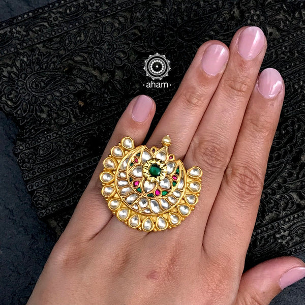 Gold polish crescent ring with Kundan work. Beautiful and wearable adjustable ring crafted in 92.5 sterling silver with green & maroon spinel embellished flower motif in the centre. Perfect for special occasions and festivities. 