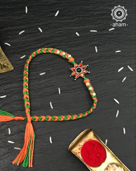 Easy to tie,  Elegant Floral Motif Silver Rakhi in 925 sterling silver for your brother weaved in Orange and Green Colour cotton thread and Pearls. Traditional Handcrafted 925 Silver rakhi. Also avaialble  Rakhi made with Ganapati, Trishul  and Om symbol. Starting with Rs.  551,  wide range of silver rakhi , 50+ rakhi designs. Gift for Sister. worldwide Shipping. Buy 925  Sterling Silver Rakhi Collection Online India.  Shop Now.