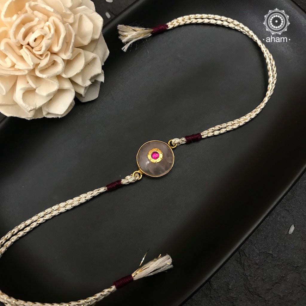 Make this Rakshabandhan Memorable with this handcrafted silver Rakhi. Elegant Rose Quartz Rakhi in 925 Silver with Gold Polish and beautiful inlay work. 