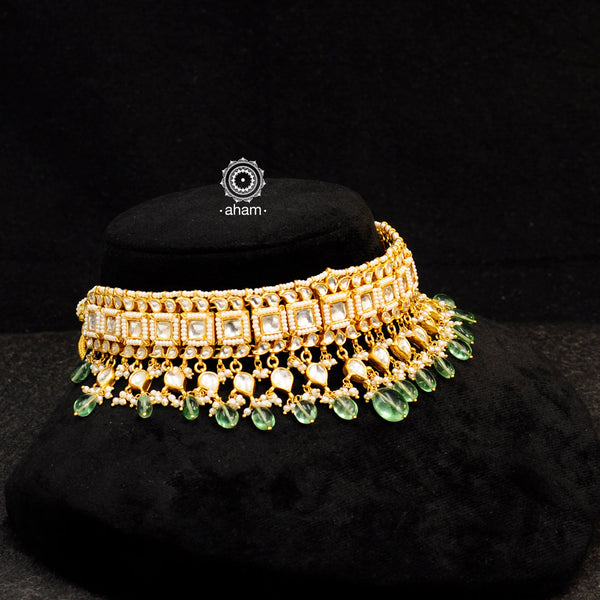Elegant gold polish kundan choker set with embellished cultured pearls. Handcrafted using traditional jadua kundan techniques in 92.5 sterling silver with semi precious green beads. Perfect for intimate weddings and upcoming festive celebrations.