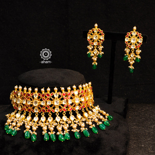 Make a sophisticated style statement with this elegant choker set with gold polish red kundan work. Handcrafted using traditional kundan jadua techniques in 92.5 sterling silver with dangling semi precious green beads and cultured pearls. Perfect for intimate weddings and upcoming festive celebrations.