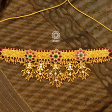 Make a sophisticated style statement this festive season with our elegant floral choker, jhumka and ring set with gold polish and red kundan work. Handcrafted using traditional Kundan Jadua techniques in 92.5 sterling silver with dangling ghungroos. The ring is adjustable and has a flower motif with embellished cultured pearls. Perfect for intimate weddings and upcoming festive celebrations.