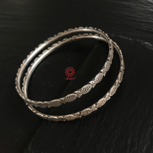Handcrafted bangle in silver with fish motifs. 